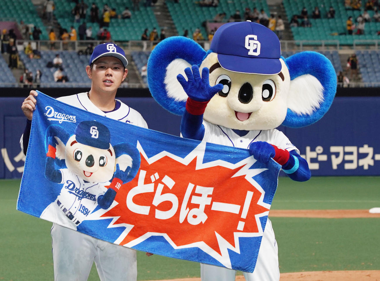 ドアラとポーズを決めるヒーローの高橋周平（撮影・森本幸一）