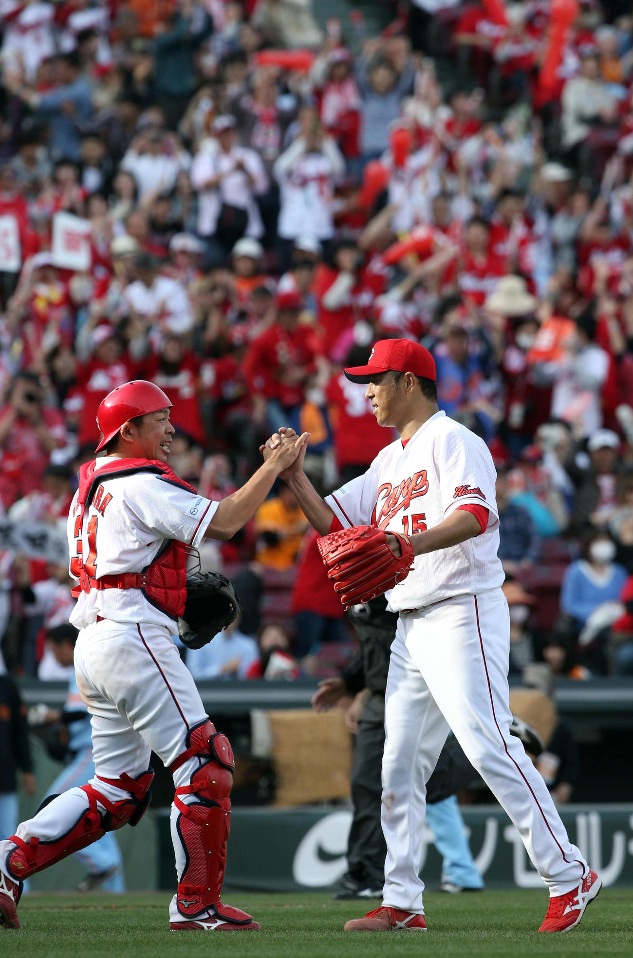 日本復帰後、初完封し石原慶幸（左）と握手を交わす黒田博樹（2016年4月2日撮影）