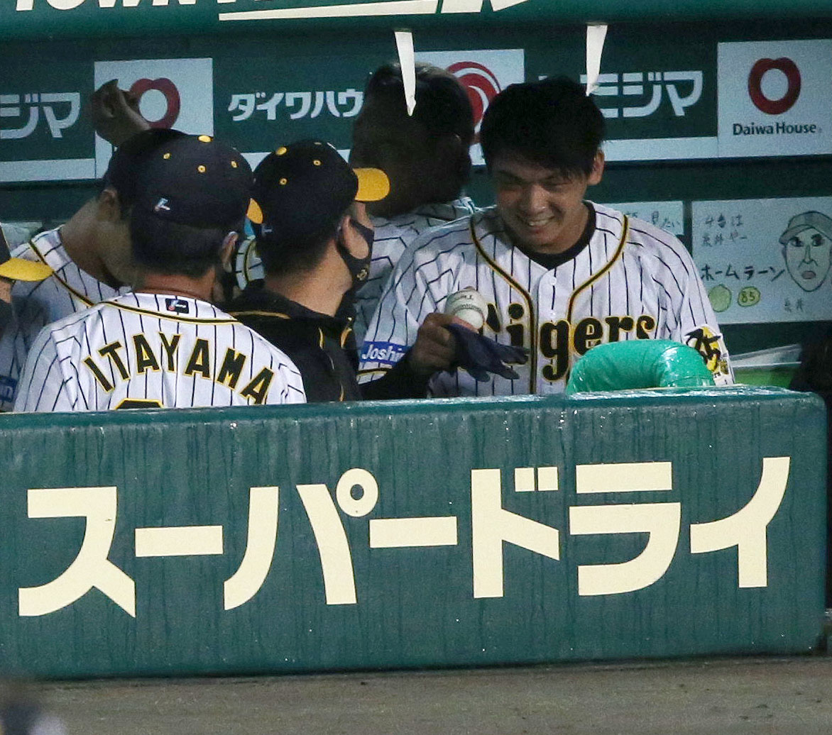 8回を終えベンチに戻った井上（右）はプロ初安打を放った記念球を受け取り笑顔を見せる（撮影・上山淳一）