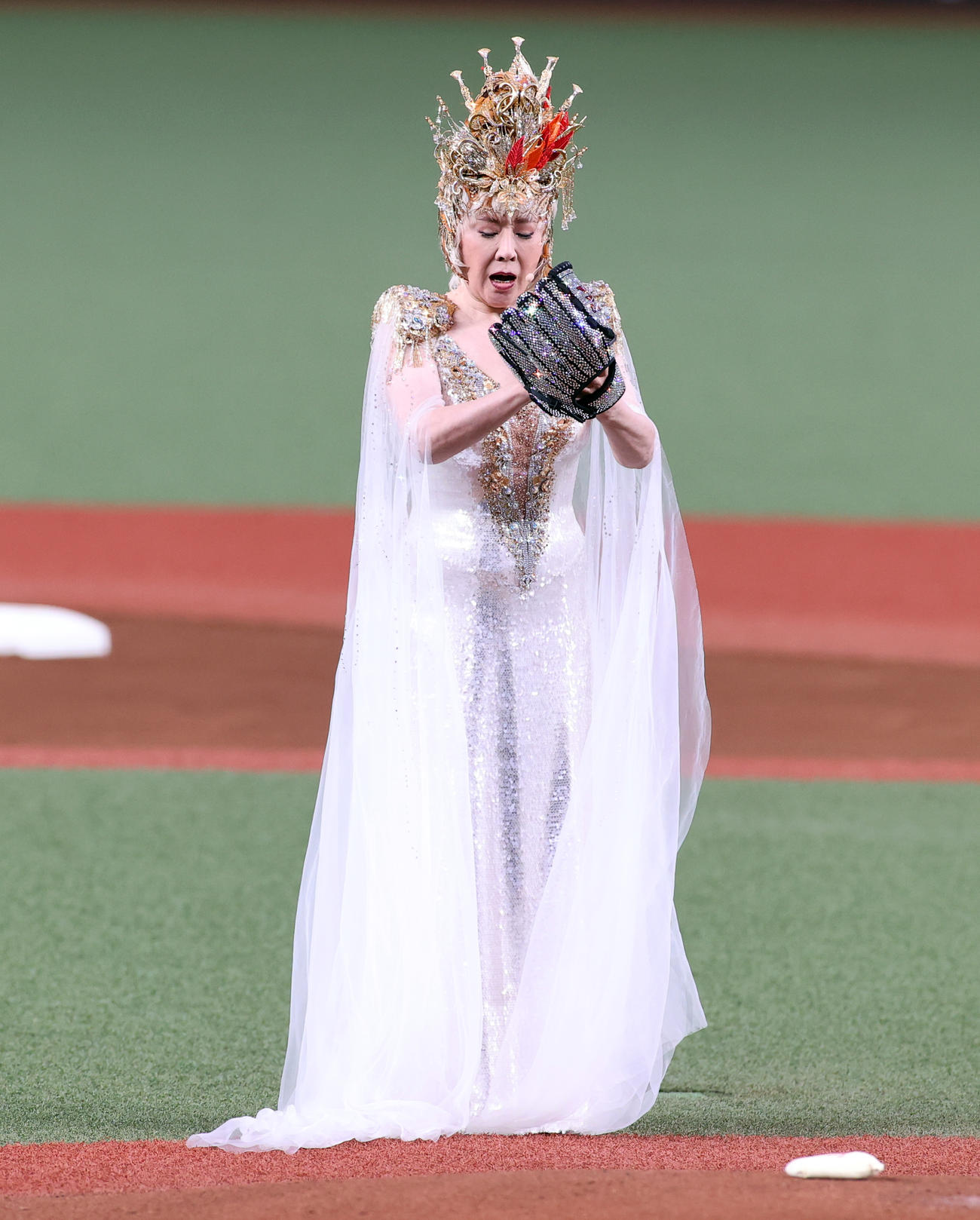 西武対オリックス　セレモニアルピッチに登場した小林幸子は、レオから輝くグラブと金のボールを受け取り投げようとして気を入れる（撮影・浅見桂子）