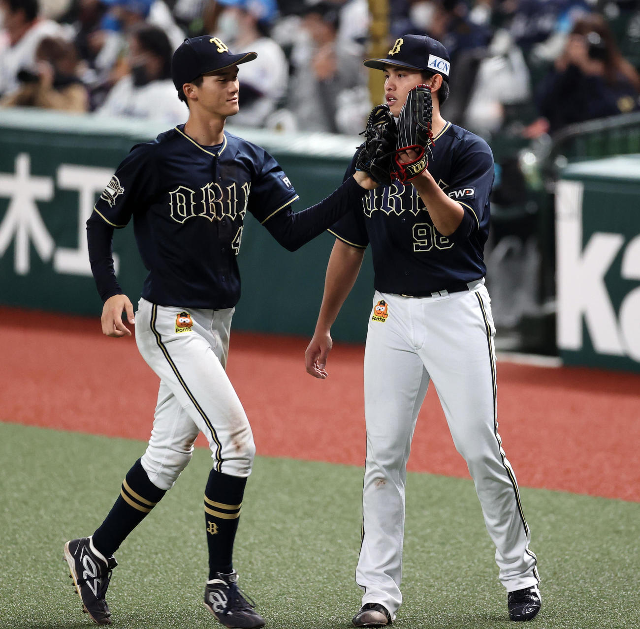 西武対オリックス　5回裏西武の攻撃を3人で抑えたオリックス先発の張奕（右）は佐野とグラブタッチ（撮影・浅見桂子）