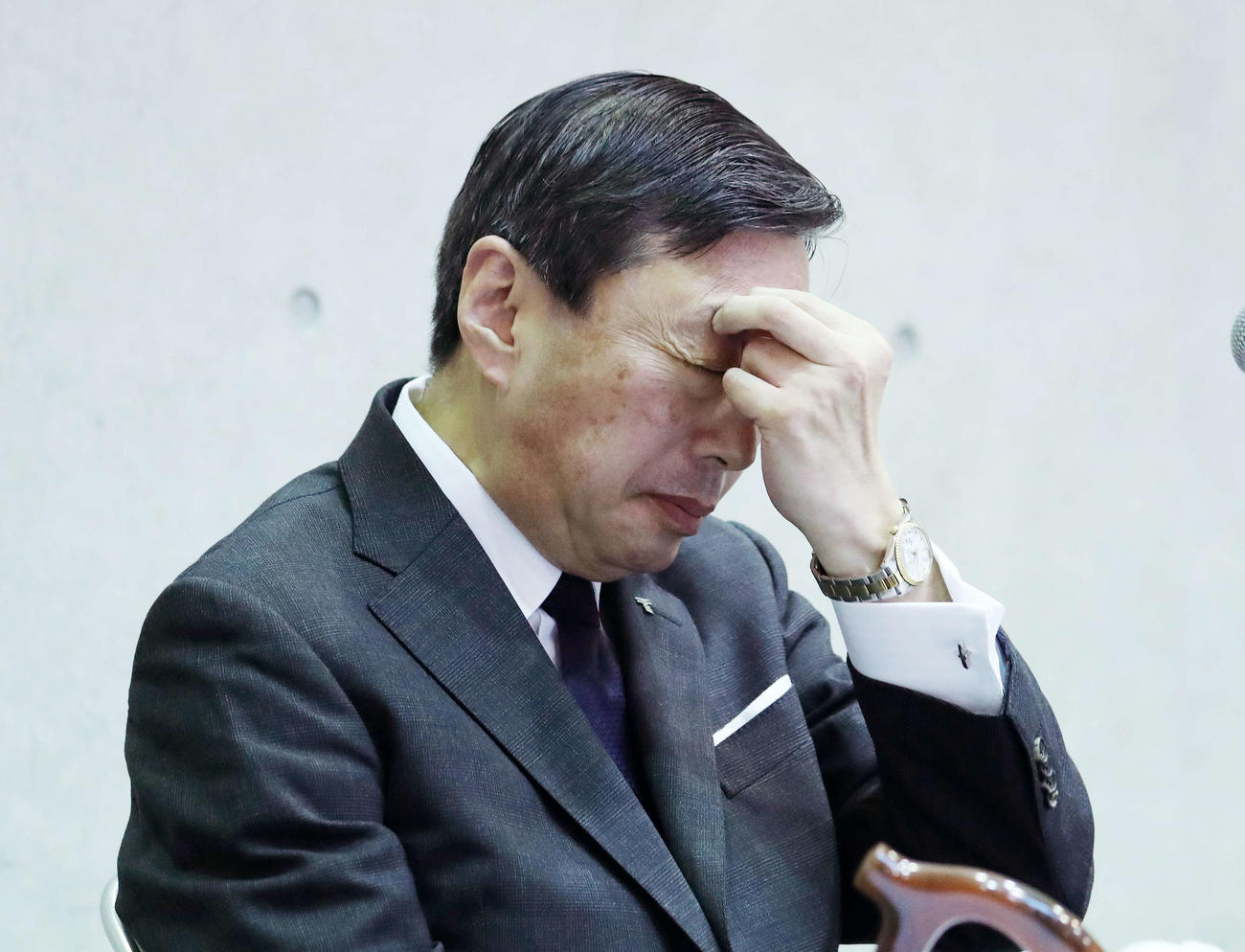 会見中、頭を押さえる山田学長（撮影・鈴木正人）