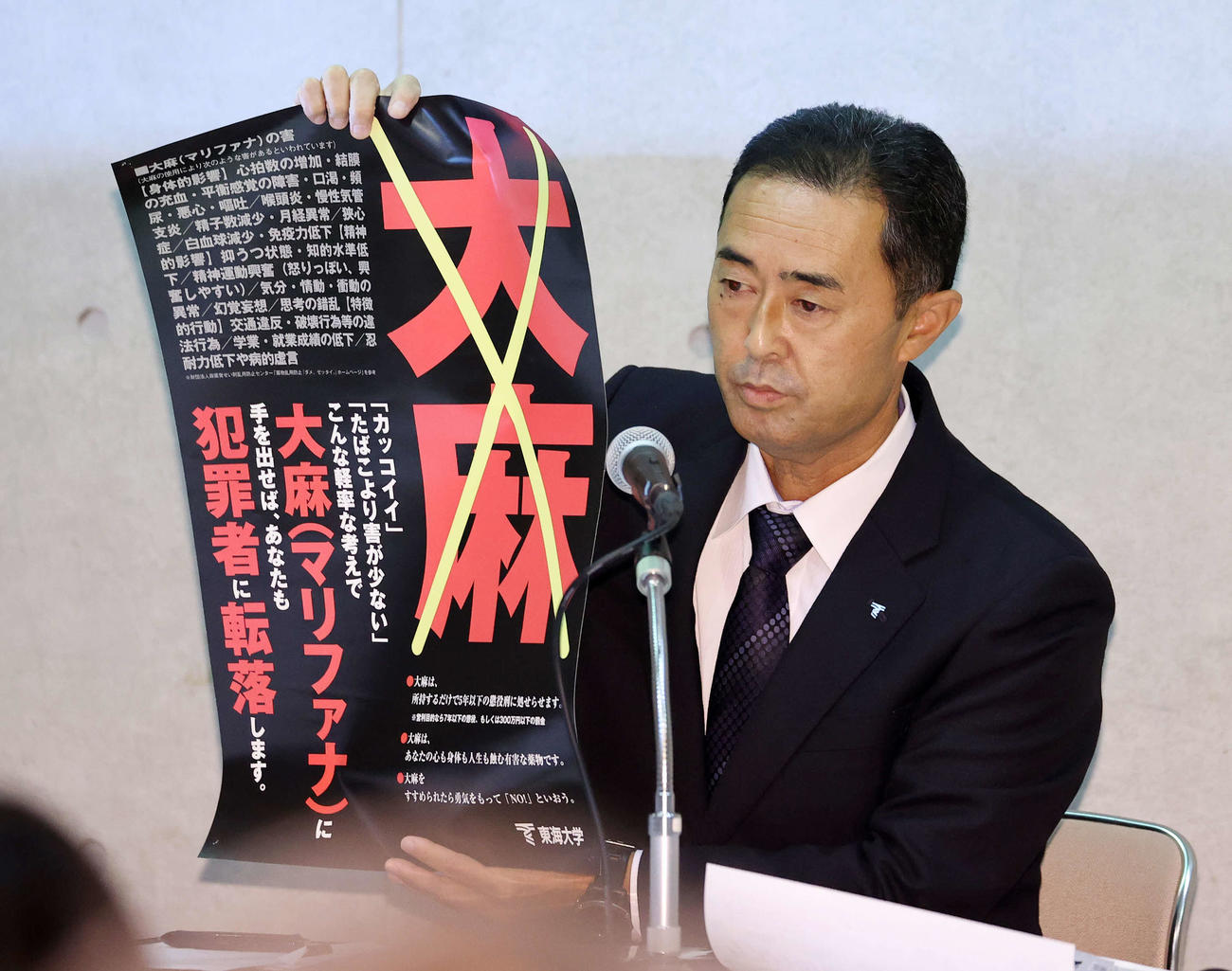 薬物乱用防止ポスターを手に質問に答える内山教学部部長（撮影・鈴木正人）