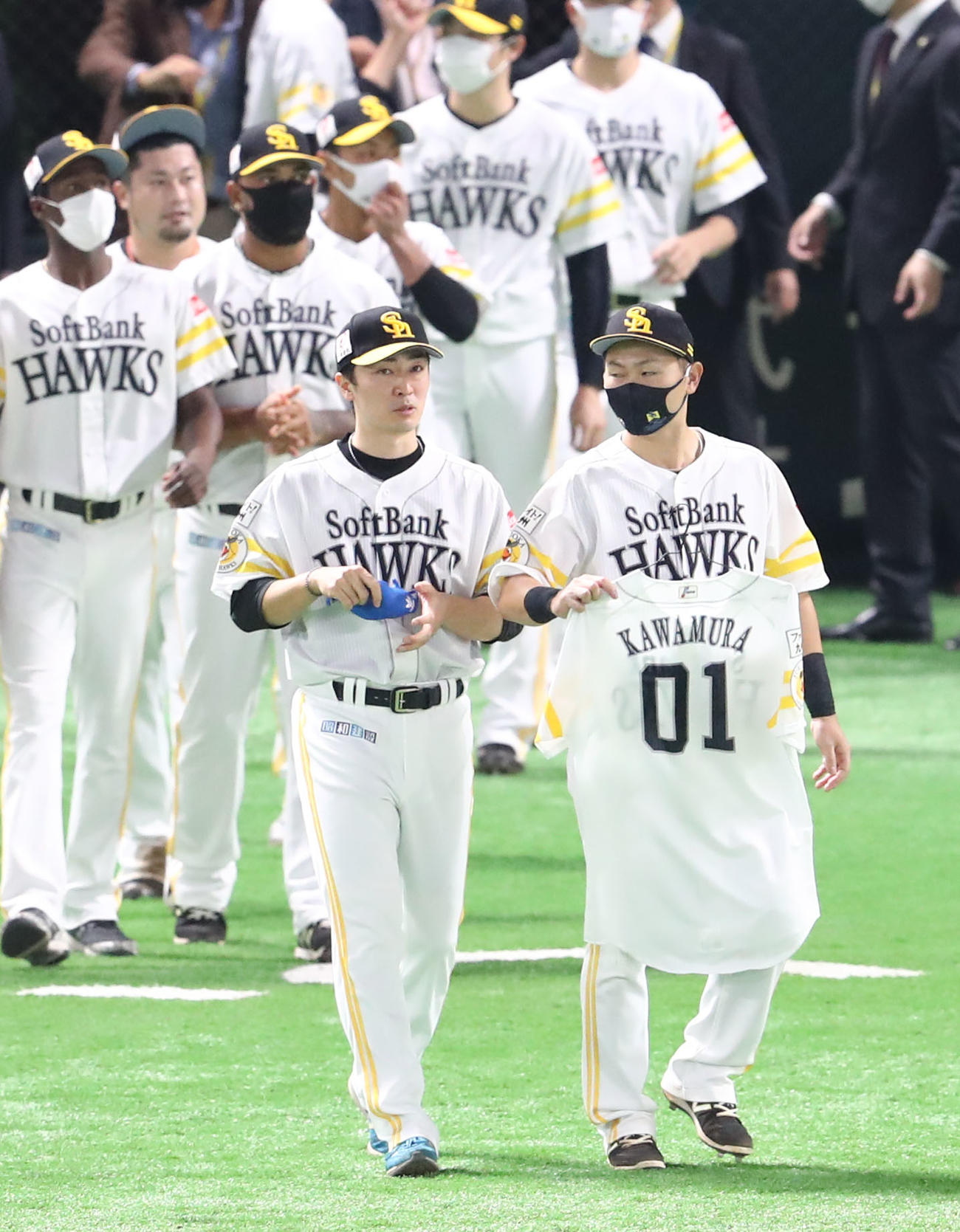 ソフトバンク対ロッテ　川村隆史コーチのユニホームを手にグラウンドにでる中村晃と和田毅（撮影・梅根麻紀）