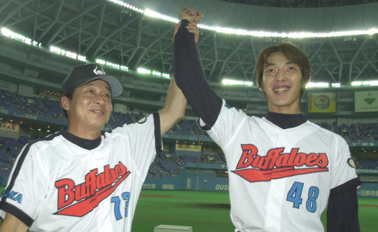 好投の岩隈久志の右腕を高々と挙げて勝利を祝う梨田昌孝監督（01年8月撮影）