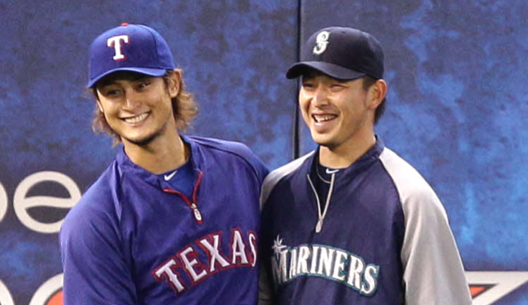 マリナーズ対レンジャーズ　試合前練習中、握手を交わし笑顔を見せる岩隈（右）とダルビッシュ（2012年5月22日撮影）