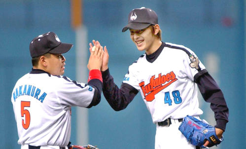 完投で2勝目を飾った岩隈久志（右）は中村紀洋と笑顔でハイタッチを交わす（02年5月撮影）