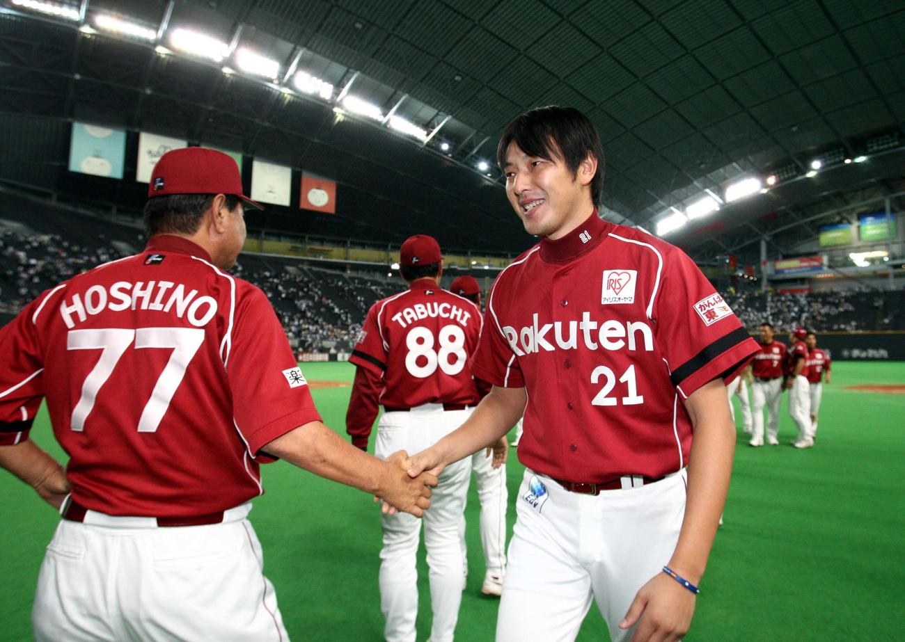 楽天時代、星野仙一監督（左）と握手する岩隈（2011年8月23日撮影）
