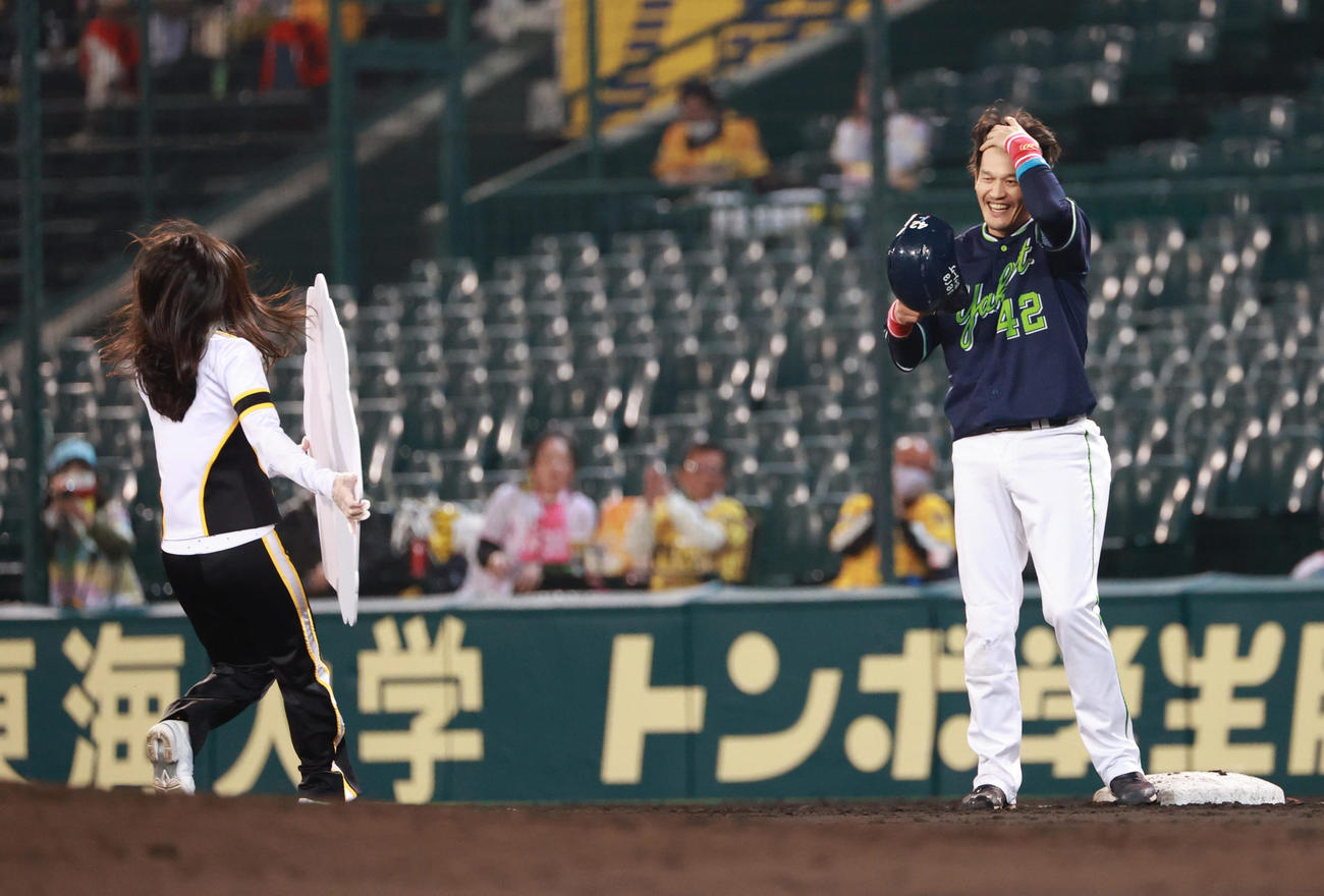 阪神対ヤクルト　4回表ヤクルト無死一、二塁、左翼線への先制適時打で通算1500安打を達成した坂口智隆、記念のボードを手にした関係者が一塁の坂口（右）をスルーし二塁に行こうとする（撮影・清水貴仁）
