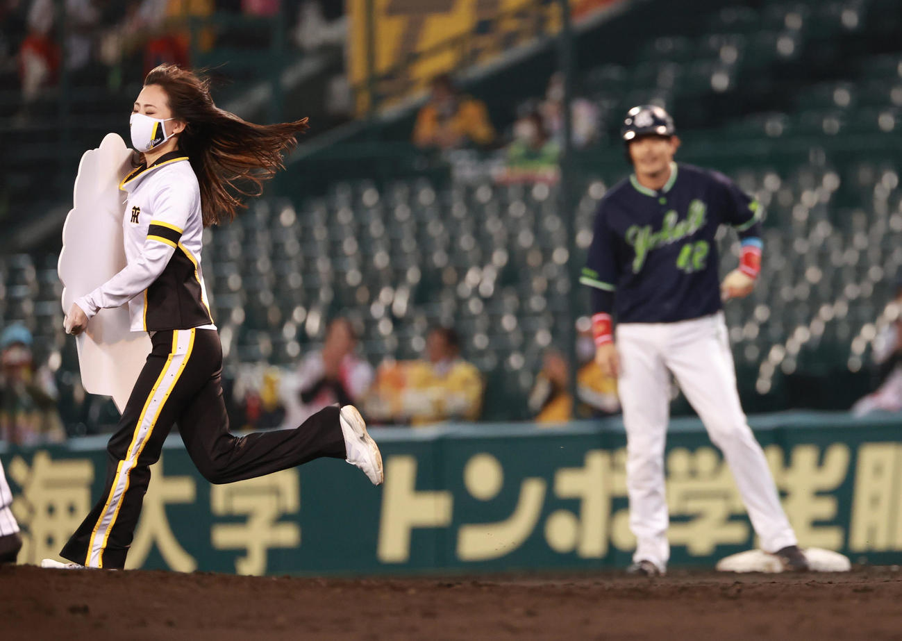 阪神対ヤクルト　4回表ヤクルト無死一、二塁、左翼線への先制適時打で通算1500安打を達成した坂口智隆、記念のボードを手にした関係者が一塁の坂口（奥）をスルーし二塁に行こうとする（撮影・清水貴仁）