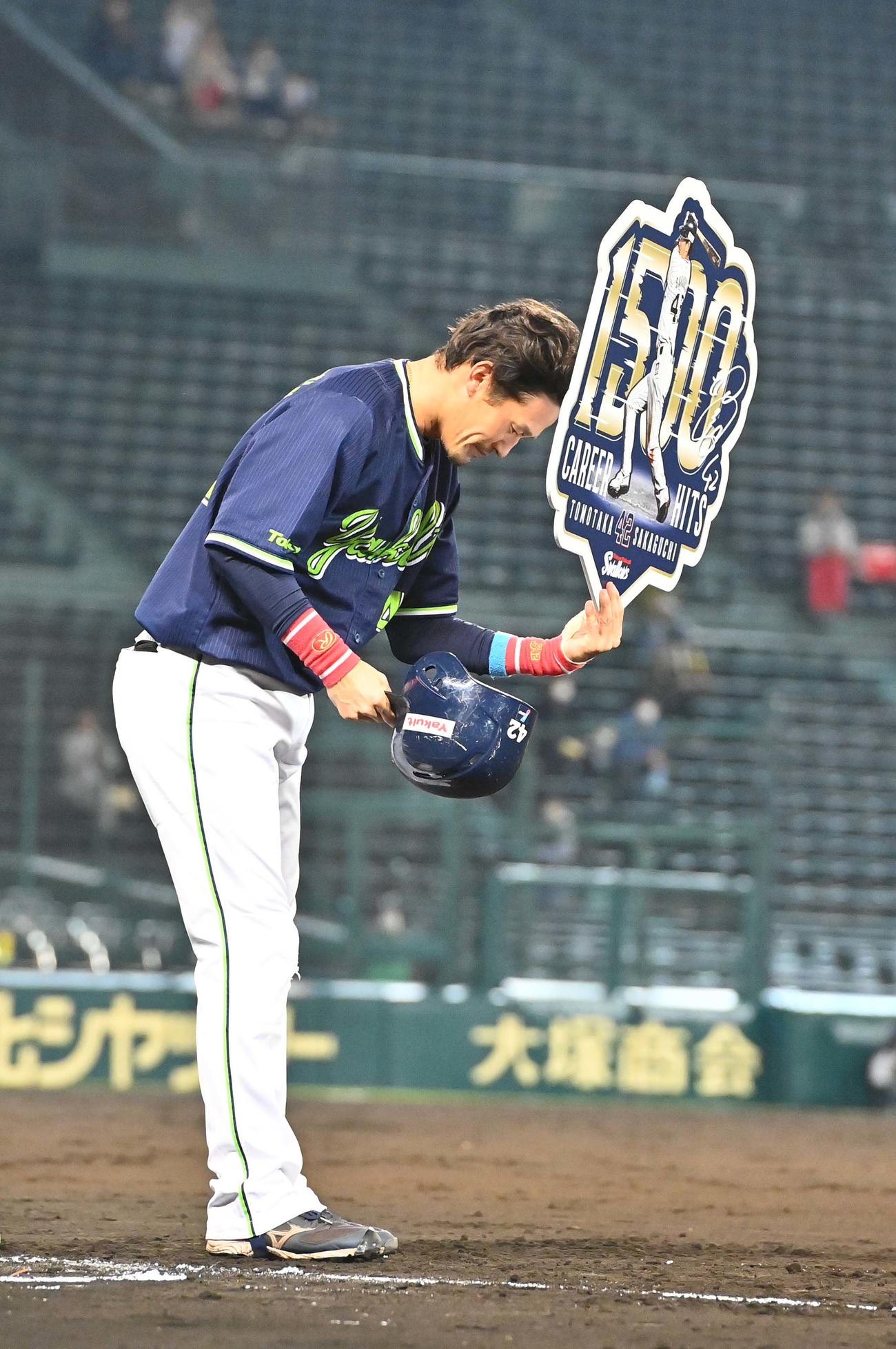 阪神対ヤクルト　4回表ヤクルト無死一、二塁、1500安打を放った坂口智隆はボードを手にファンに頭を下げる（撮影・上田博志）