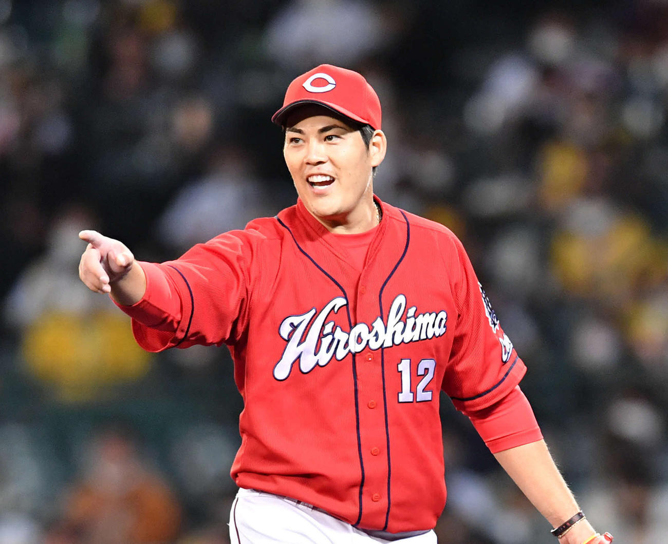 6回裏、笑顔でナインを指さしながらベンチへ戻る九里（撮影・岩下翔太）