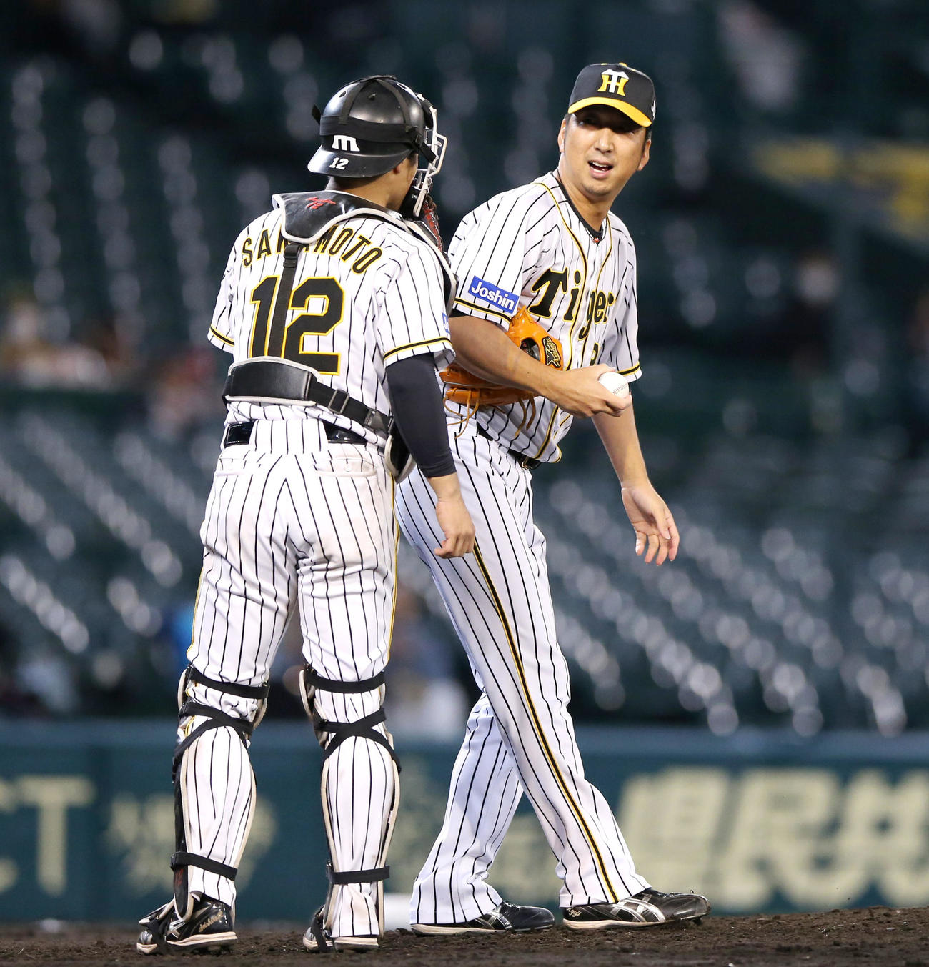 6回表、藤川（右）がマウンドに上がり坂本と話す（撮影・上山淳一）