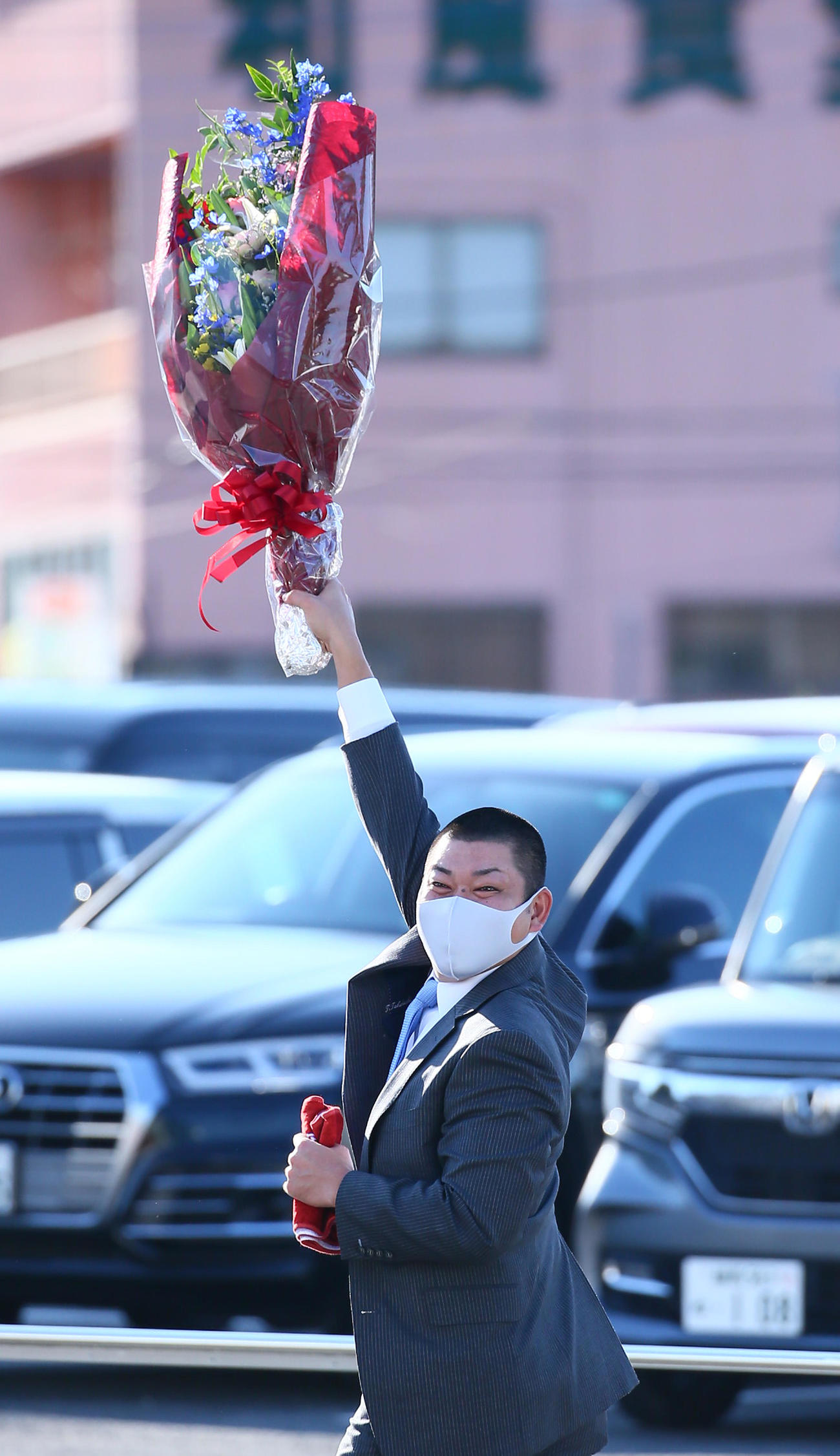 引退会見を終え、花束を手に球団事務所を後にする西武高橋朋（撮影・足立雅史）