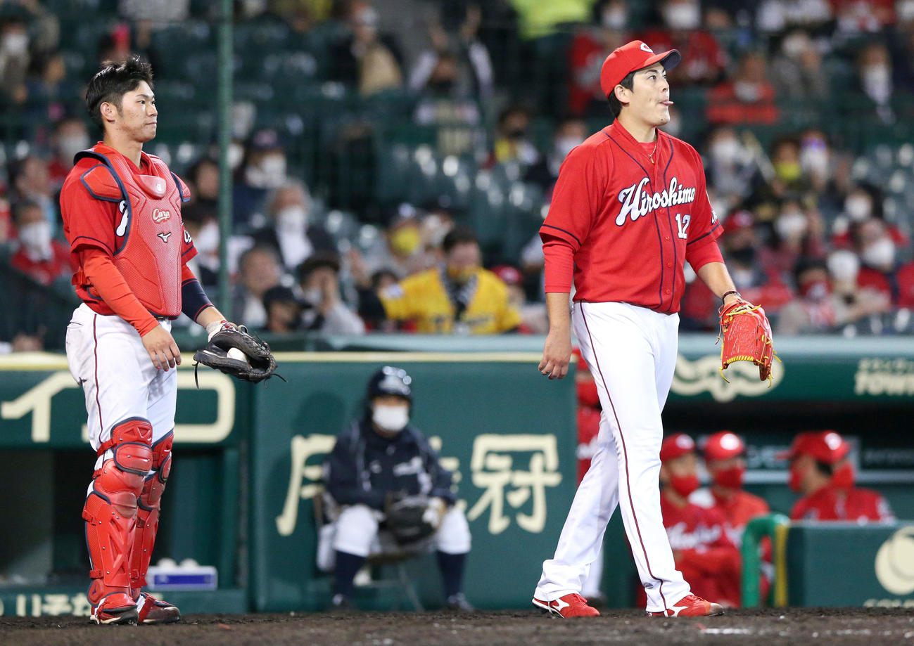 阪神対広島　9回裏阪神1死一、二塁、九里（右）は糸井に右前適時打を打たれ悔し気に舌を出す（撮影・上山淳一）