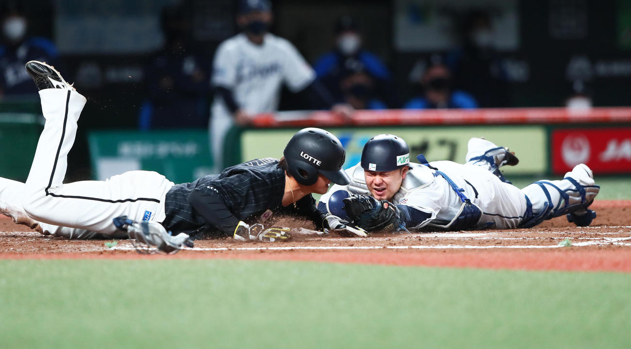 西武対ロッテ　3回表ロッテ1死三塁、藤原の左犠飛にヘッドスライディングで生還する藤岡（左）。捕手森（撮影・足立雅史）
