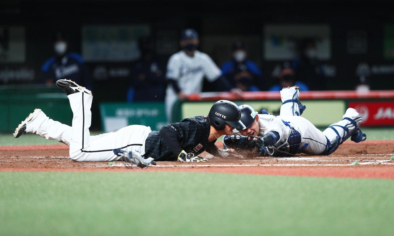 西武対ロッテ　3回表ロッテ1死三塁、藤原の左犠飛にヘッドスライディングで生還する藤岡（左）。捕手森（撮影・足立雅史）
