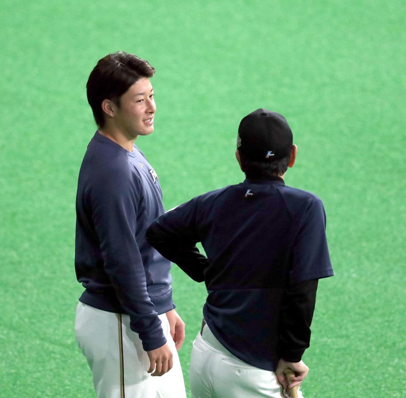 日本ハム対ソフトバンク　試合前、言葉を交わす日本ハム吉田輝（左奥）と栗山監督（撮影・佐藤翔太）