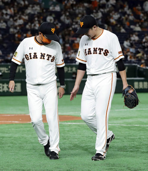 巨人対阪神 7回表、マウンドに上がった菅野(右)だが、右手を気にする様子を見せベンチにいったん引き揚げる。左は宮本コーチ(撮影・河野匠)