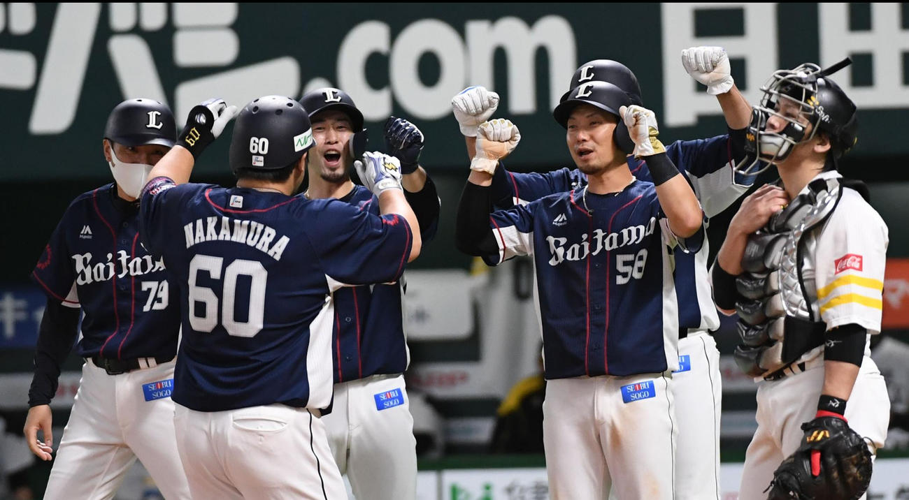 ソフトバンク対西武　8回表西武1死満塁、中村は左中間に逆転の満塁本塁打を放ち、ホームでナインに迎えられる（撮影・今浪浩三）