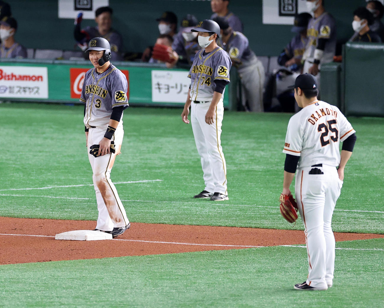 巨人対阪神　7回表阪神2死一塁、木浪の中前打で三塁に進塁した大山（左）は笑顔で岡本に何か声をかける（撮影・浅見桂子）