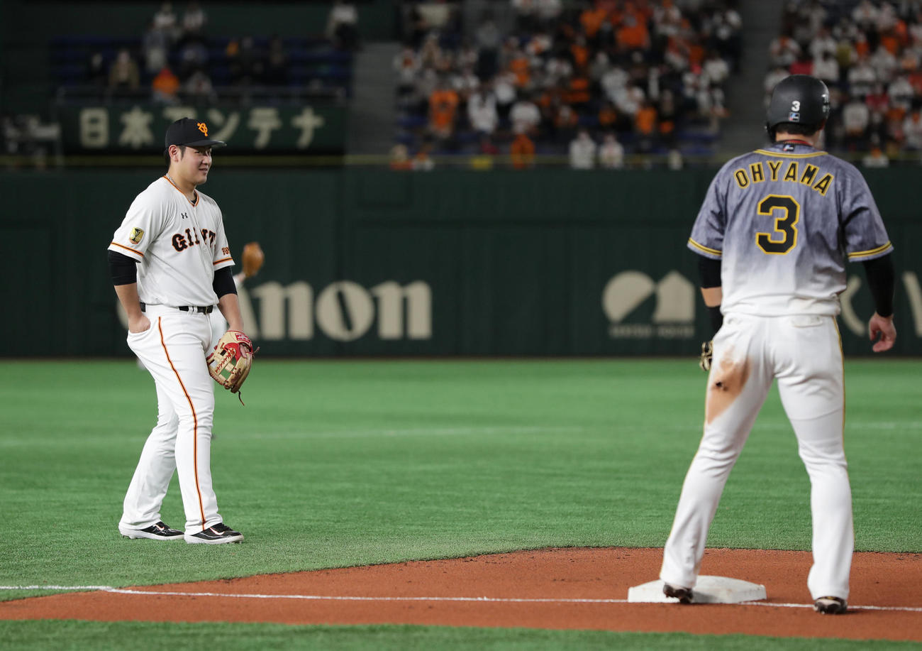 巨人対阪神　7回表阪神2死一塁、木浪の中前打へ三塁へ進んだ大山（右）に向かってほほ笑む三塁手岡本（撮影・前田充）