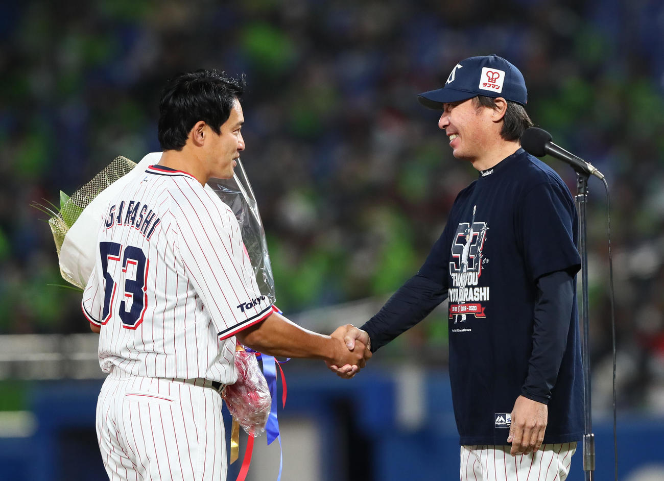 ヤクルト対中日　引退セレモニーでヤクルト五十嵐（左）は高津督から花束を受け取り笑顔を見せる（撮影・足立雅史）