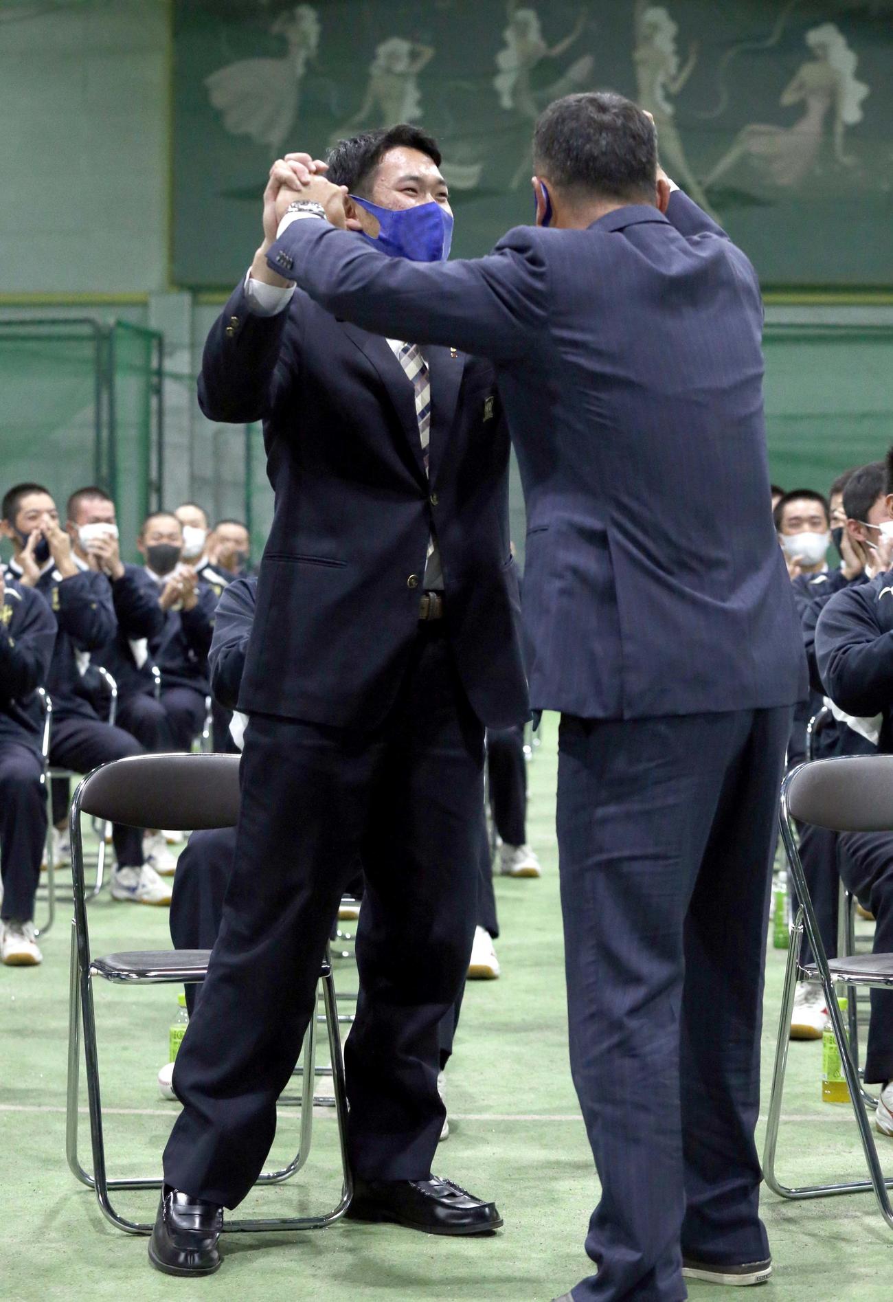 日本ハムドラフト5位指名を受け苫小牧中央・根本（左奥）は渡辺監督と喜び合う（撮影・佐藤翔太）