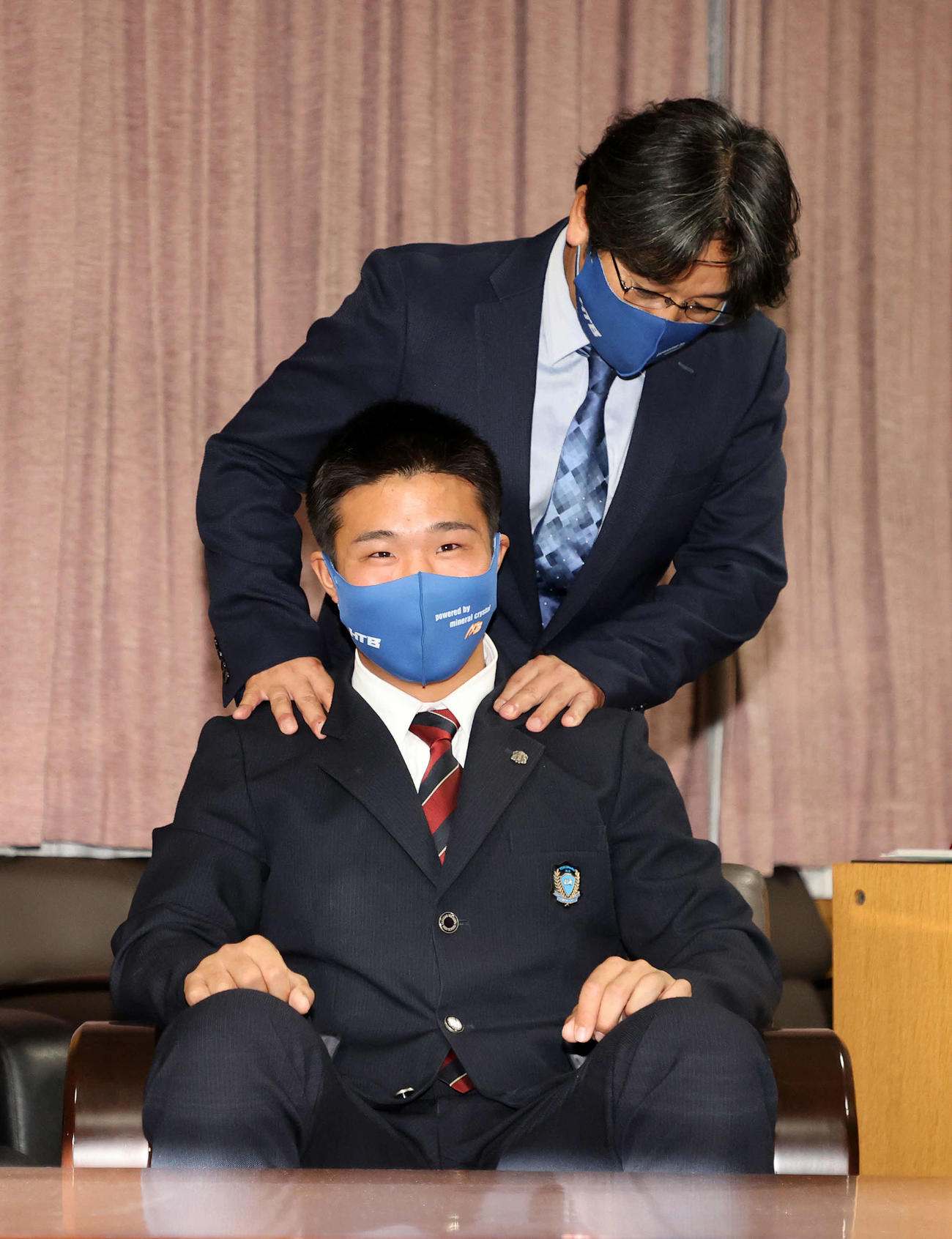 ソフトバンクに1位指名され岩井監督（上）に肩をもまれる花咲徳栄・井上（撮影・鈴木正人）