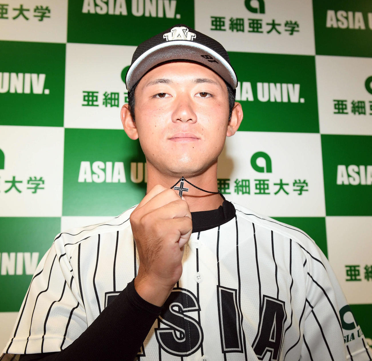 巨人から外れ1位で指名された亜大・平内は祖父の遺骨の入ったペンダントを披露する（撮影・滝沢徹郎）