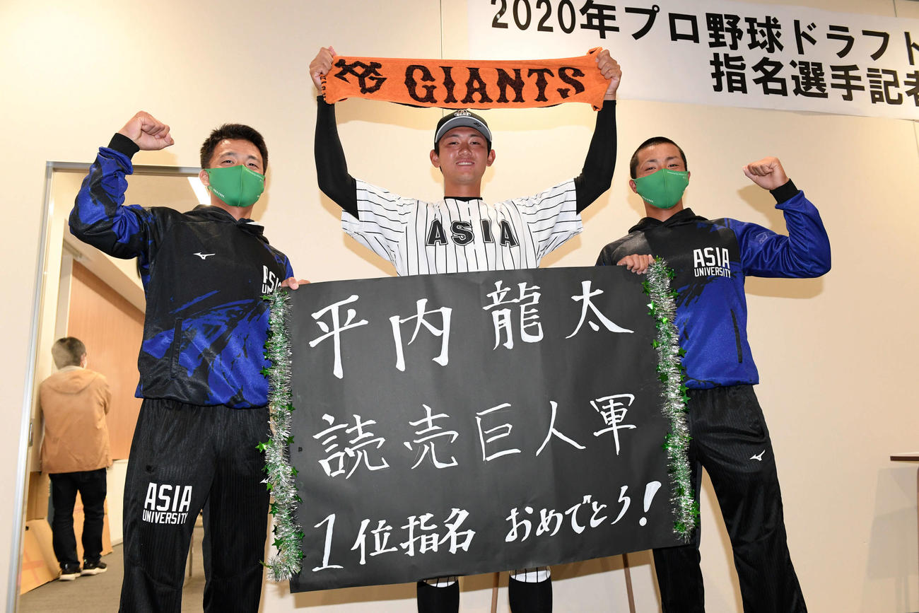 巨人から外れ1位指名を受け記念撮影する亜大・平内（中央）（撮影・滝沢徹郎）