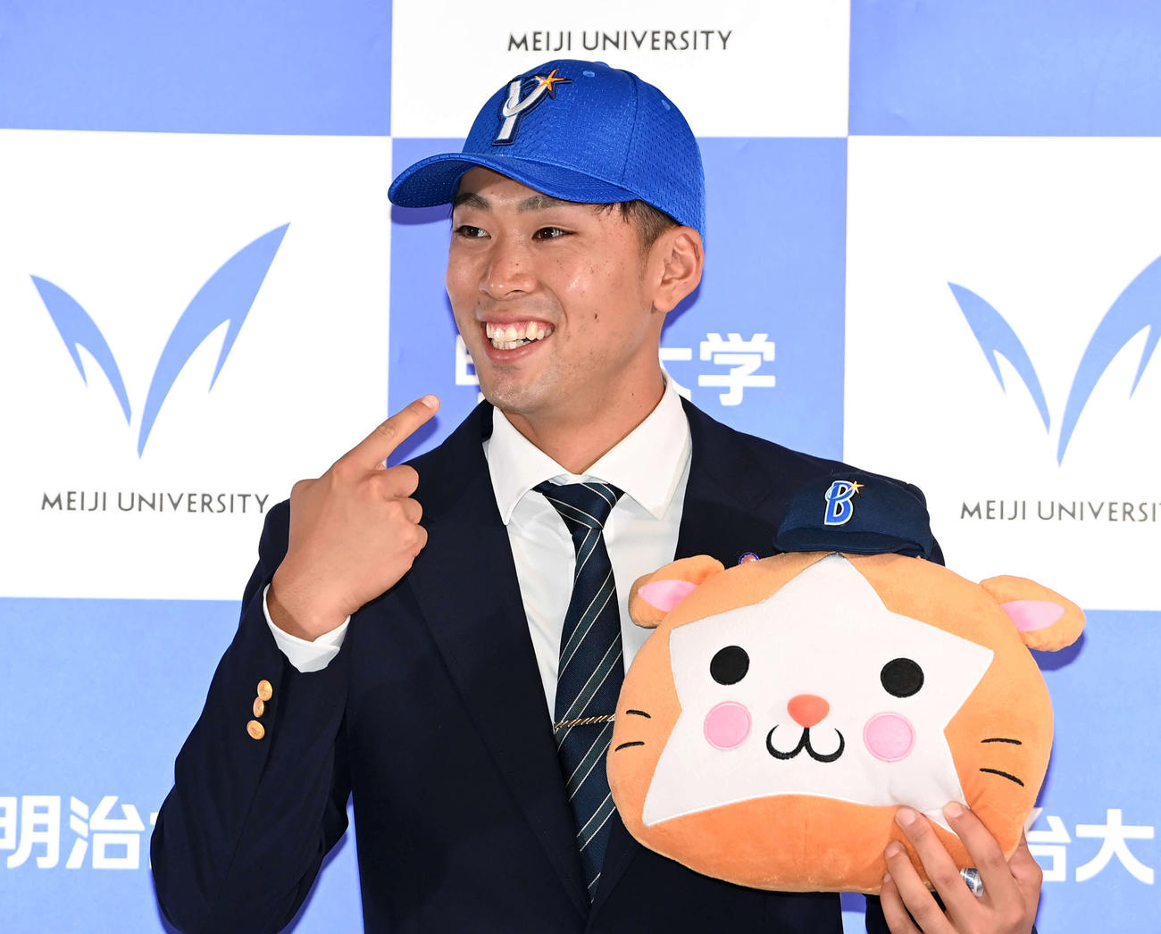 DeNAからドラフト1位指名を受けた明大・入江はDB.スターマンのぬいぐるみを手に笑顔（撮影・鈴木みどり）
