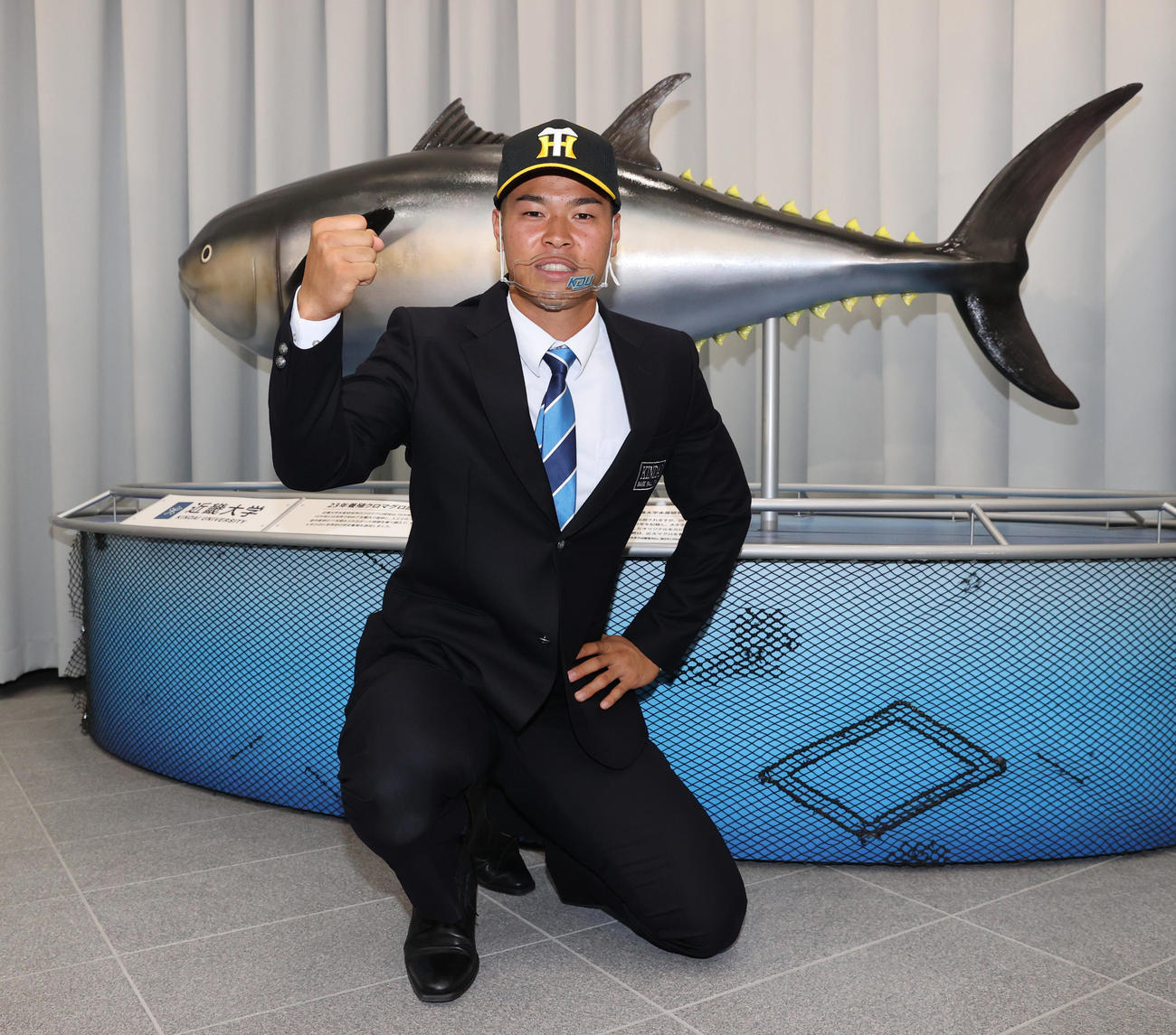 近大マグロの前でポーズを取る阪神ドラフト1位近大の佐藤輝明（撮影・清水貴仁）