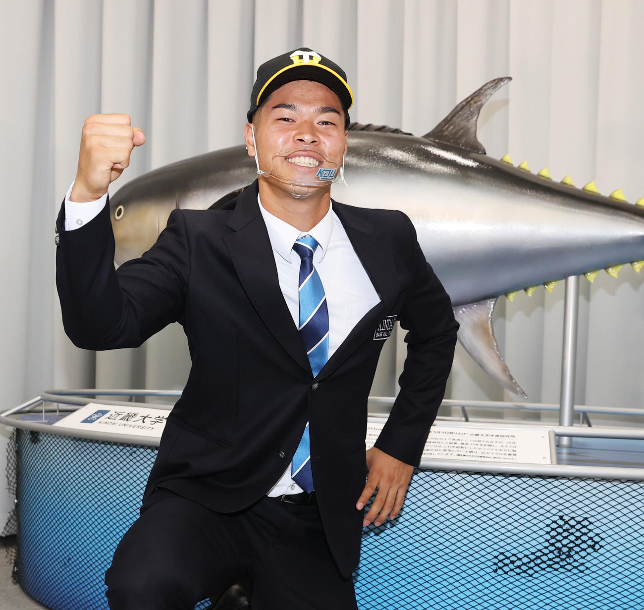 近大マグロの前でポーズを取る阪神ドラフト1位近大の佐藤（撮影・清水貴仁）