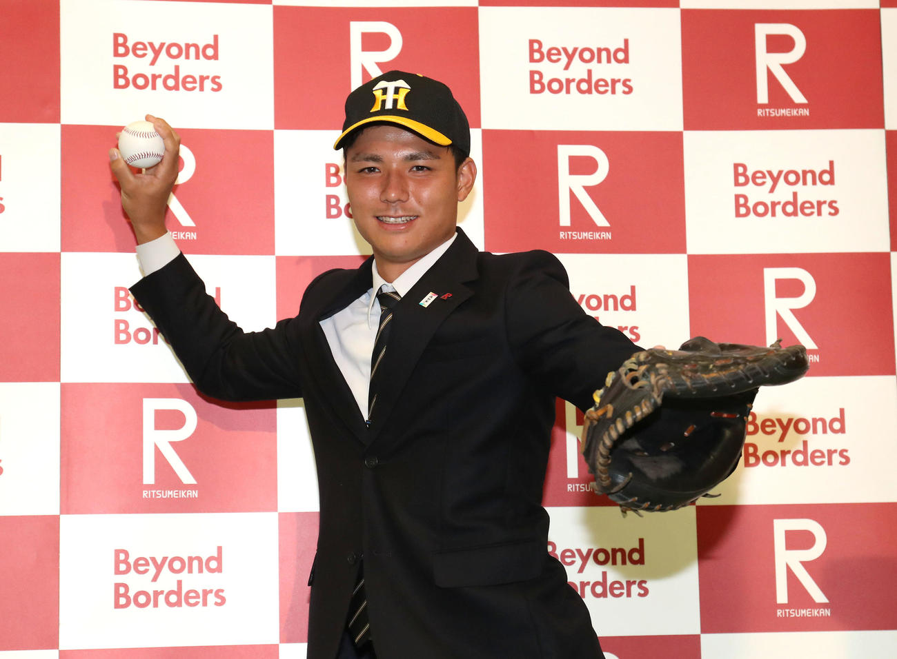 阪神から4位指名を受けて笑顔で捕手ポーズをする立命大・栄枝（撮影・白石智彦）