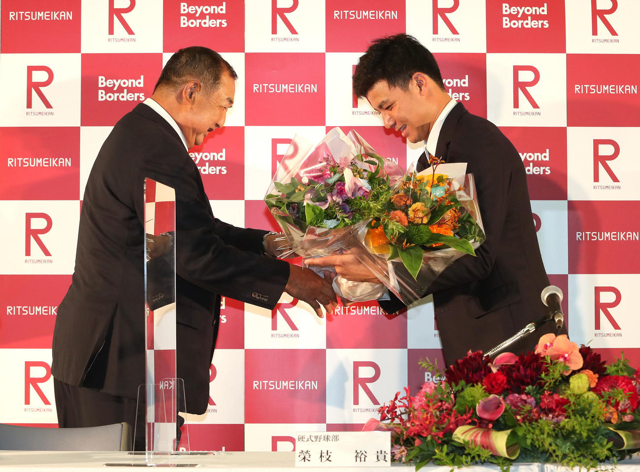 阪神から4位指名を受けて、後藤昇監督（左）から花束を受け取る栄枝裕貴（撮影・白石智彦）