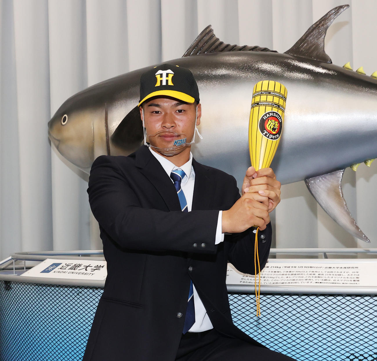 近大マグロの前でポーズを取る阪神ドラフト1位近大の佐藤輝明（撮影・清水貴仁）