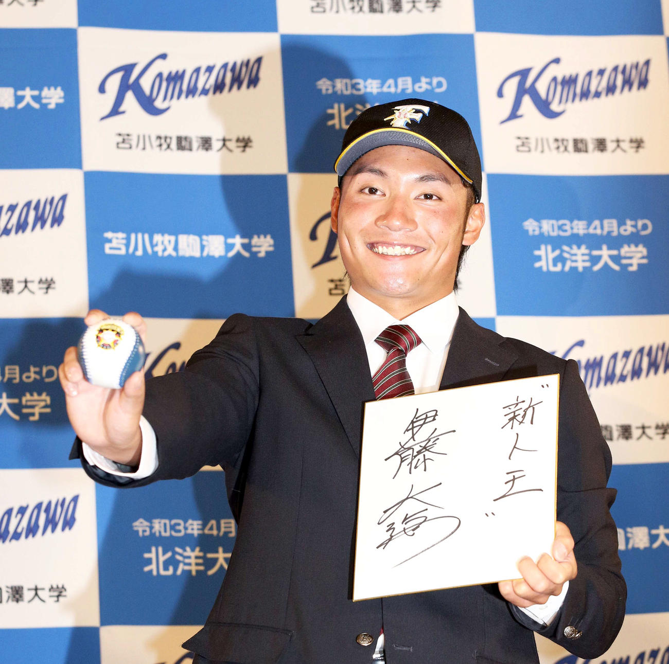 日本ハムから1位指名を受け「新人王」と色紙に記し笑顔で撮影に応じる苫小牧駒大・伊藤（撮影・佐藤翔太）