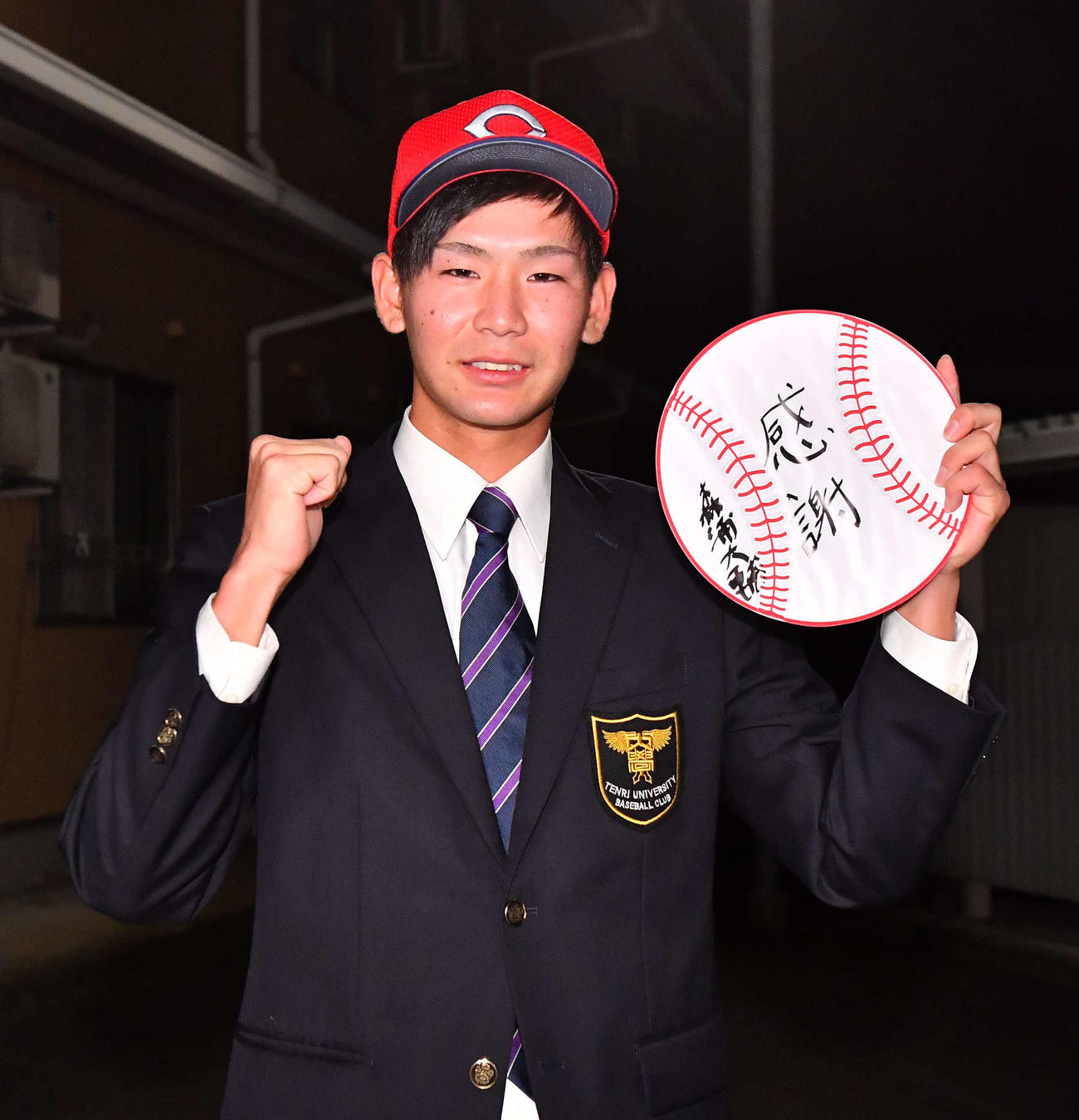 広島2位で指名された天理大・森浦大輔は「感謝」と書いた色紙を手に笑顔を見せる（撮影・上田博志）