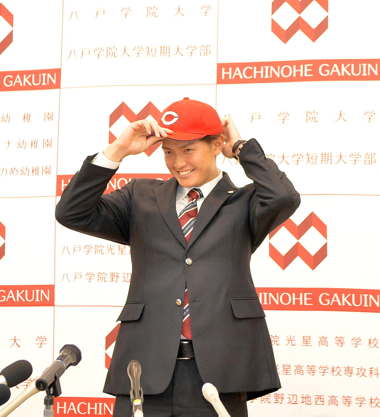 広島の帽子を笑顔でかぶる八戸学院大・大道（撮影・鎌田直秀）