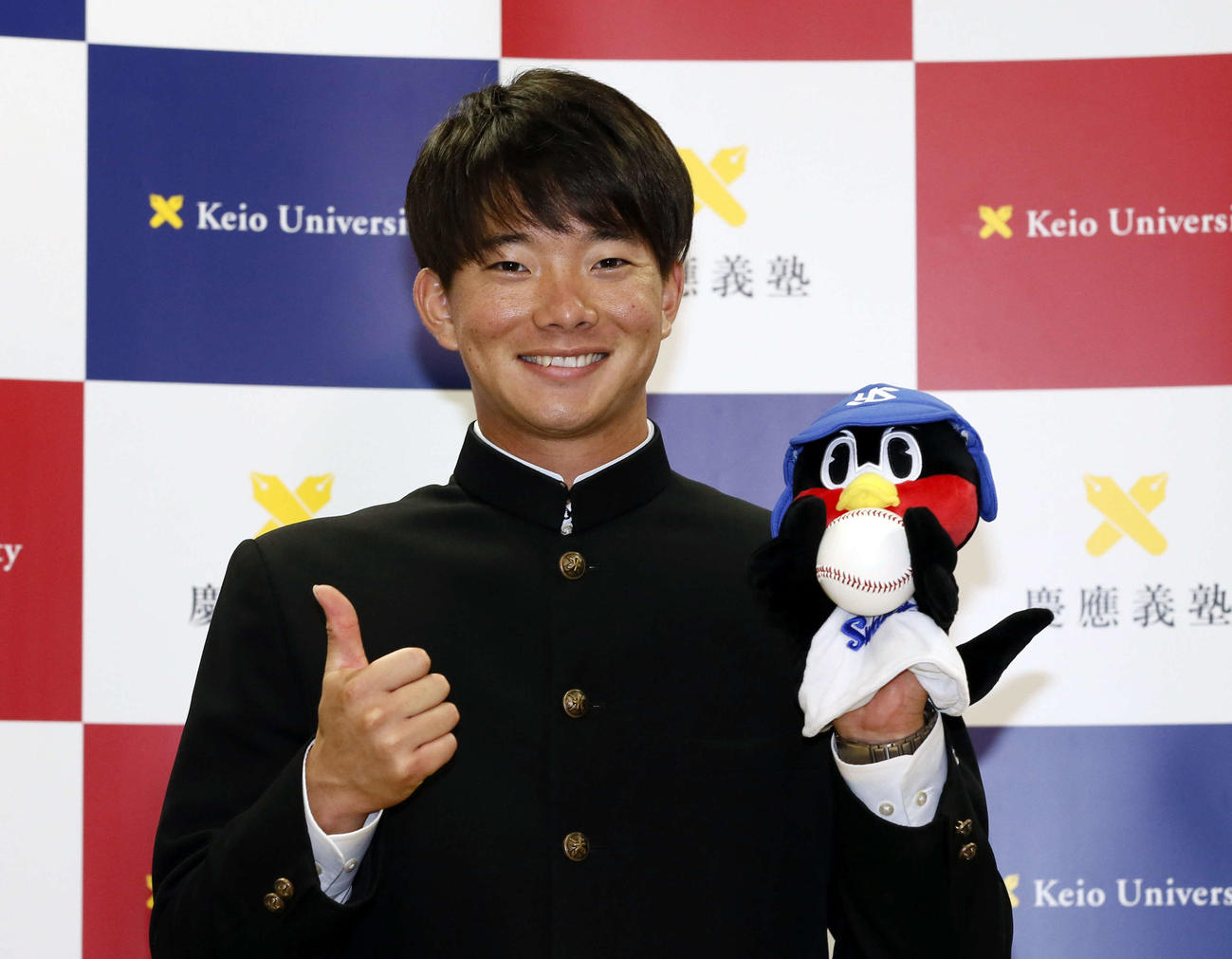 ヤクルトに1位で指名され、マスコットを手に笑顔を見せる慶大・木沢（代表撮影）
