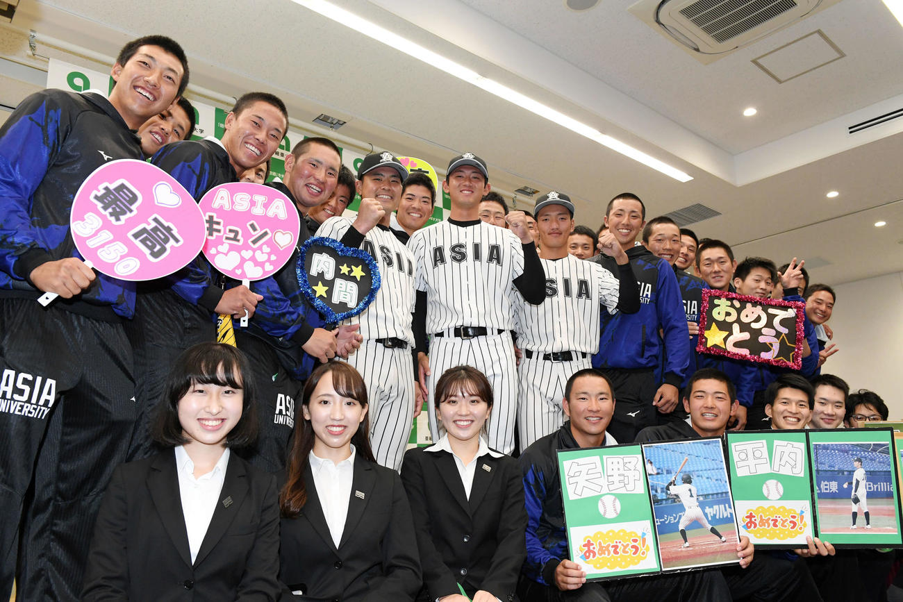 チームメートと記念撮影する巨人から外れ1位で指名された亜大・平内（中央）、楽天4位指名の内間（中左）、広島6位指名の矢野（中右）（撮影・滝沢徹郎）