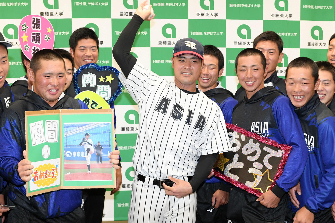 楽天から4位指名された亜大・内間は楽天の帽子をかぶりシャドーピッチングを披露する（撮影・滝沢徹郎）