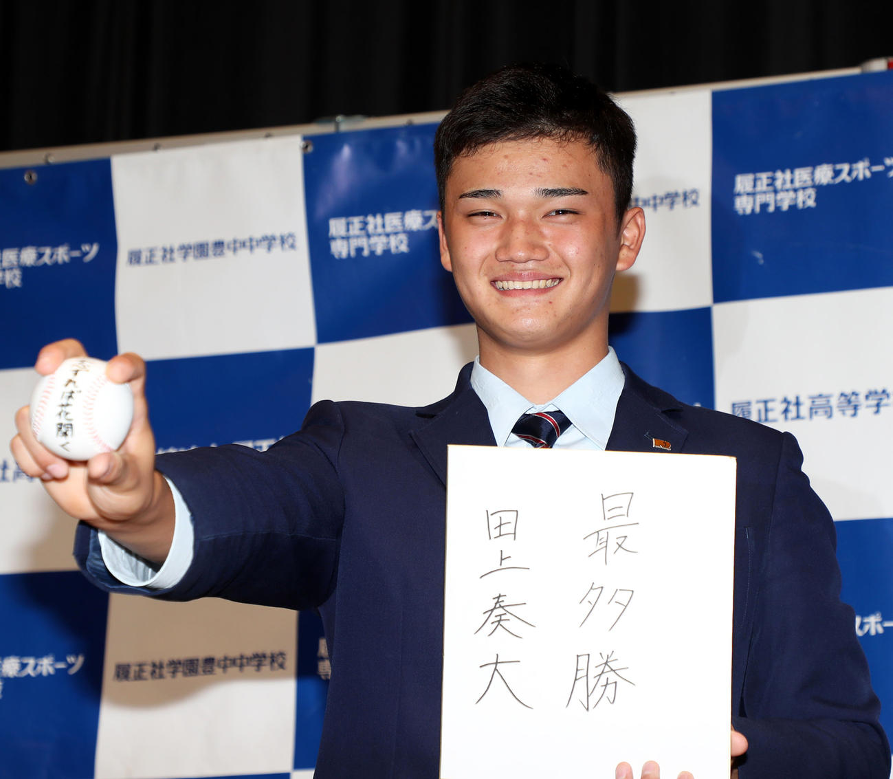 ソフトバンクから5位指名を受け目標を書いた色紙を手に笑顔を見せる田上（撮影・加藤哉）