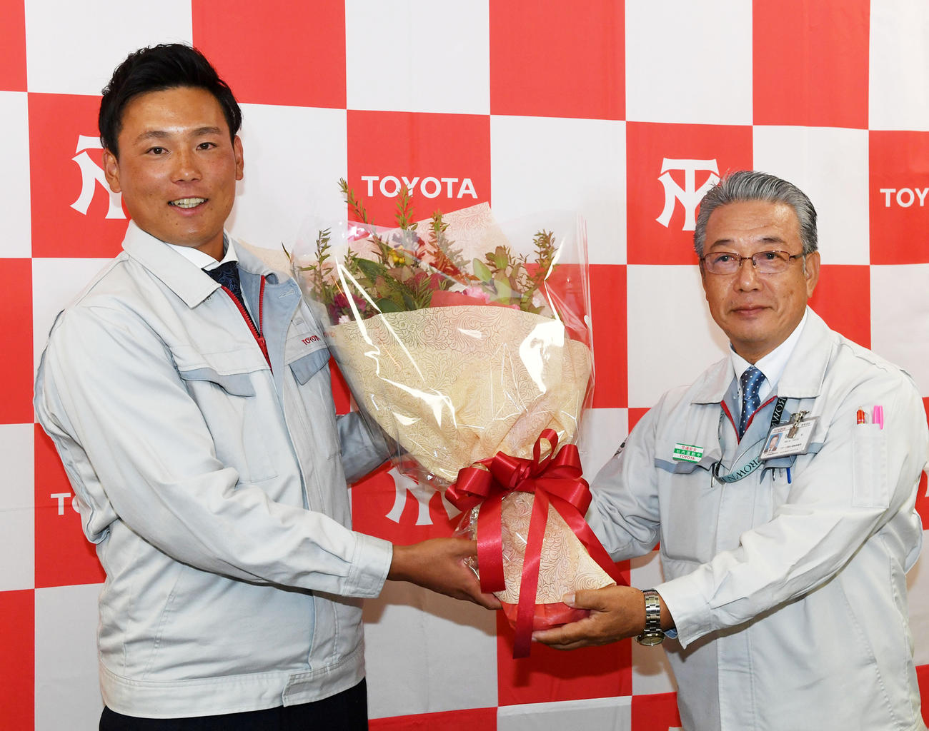 広島に1位で指名され笑顔で牧野武スポーツ強化・地域貢献部長（右）から花束を受け取るトヨタ自動車の栗林良吏（撮影・前岡正明）