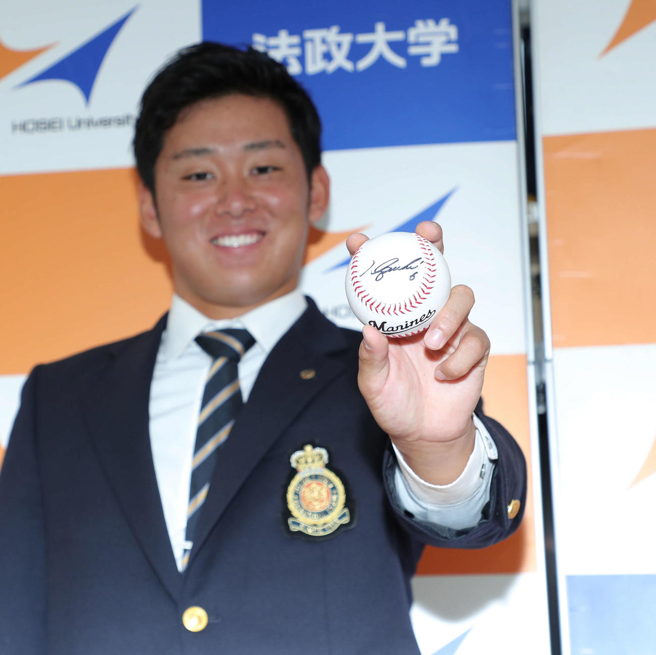 井口監督のサインボールを手に、笑顔で写真に納まるロッテ1位指名の法大・鈴木（撮影・河田真司）