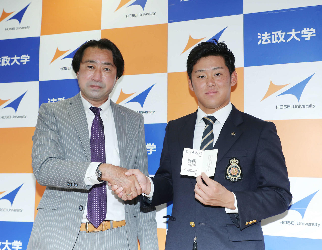 井口監督が引き当てた交渉権確定当たりくじを手に、中川担当スカウトと笑顔で写真に納まるロッテ1位指名の法大・鈴木（撮影・河田真司）