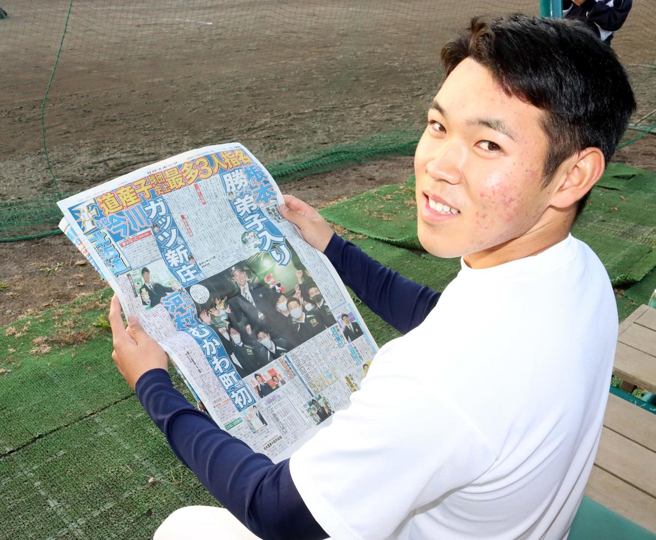 根本はドラフト結果が報じられた日刊スポーツ北海道版を手に笑顔（撮影・永野高輔）