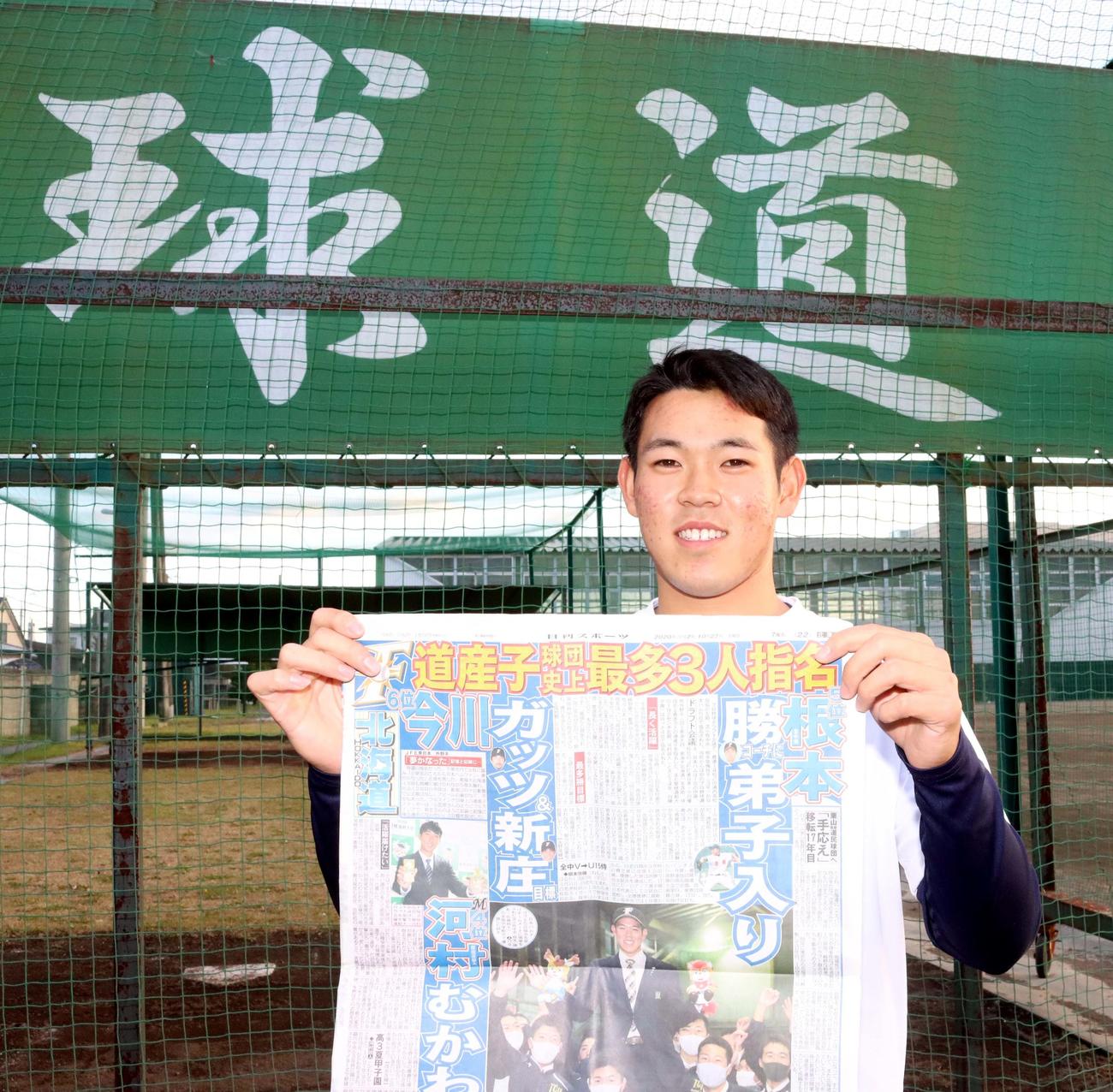 根本はドラフト結果が報じられた日刊スポーツ北海道版を手に笑顔（撮影・永野高輔）