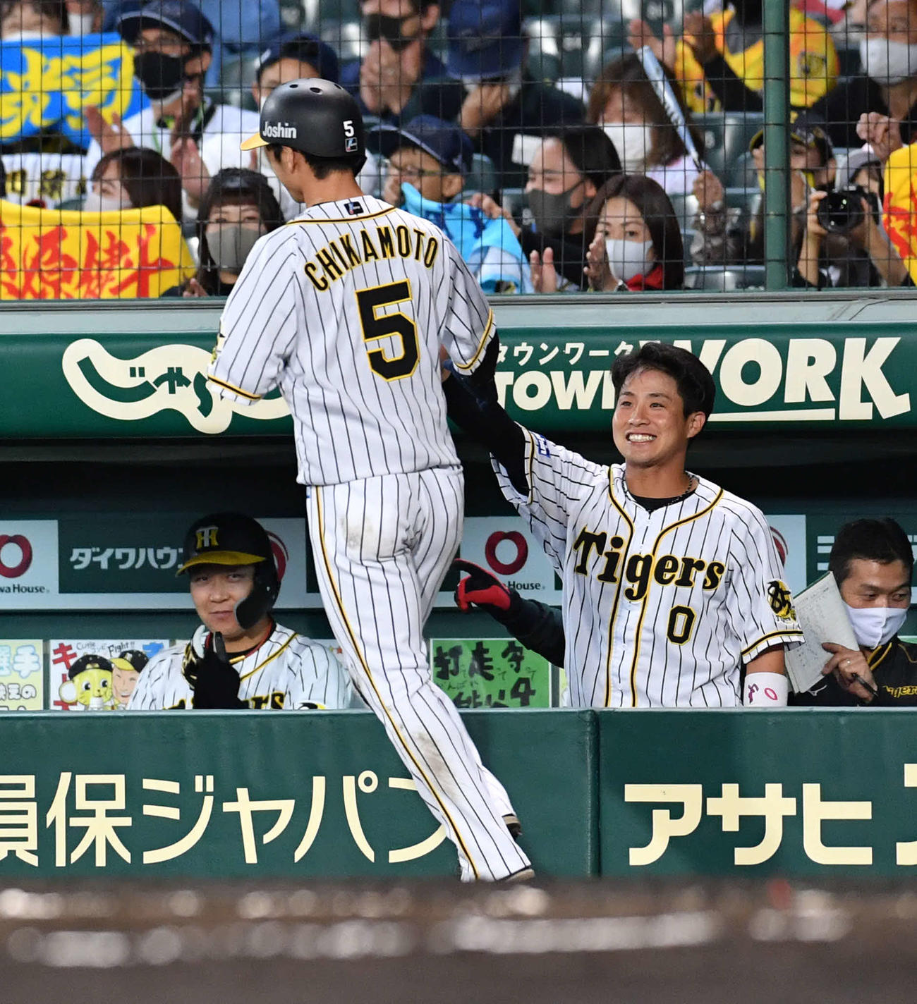 阪神対中日22回戦　8回裏阪神2死三塁、糸原健斗の適時内野安打で生還した近本光司（中央）を笑顔で迎える木浪聖也（右）、左は大山悠輔（撮影・岩下翔太）